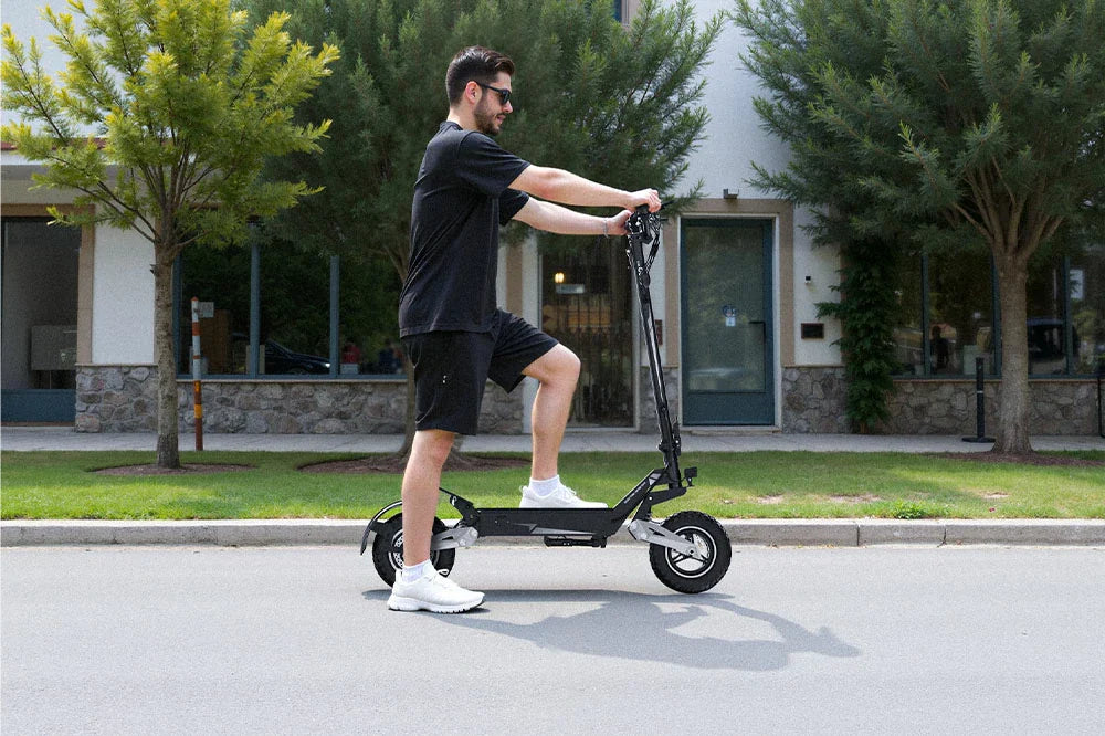 Black foldable electric scooter in use: Rider navigating a suburban neighborhood, highlighting the scooter’s sleek frame and practical commuter features