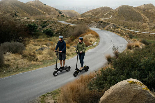 Two people wearing helmets riding powerful off‑road electric scooters on mountain country road, outdoor adventure e‑scooter for hill terrain