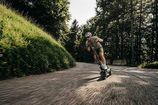 Man riding off‑road electric scooter on forest mountain road