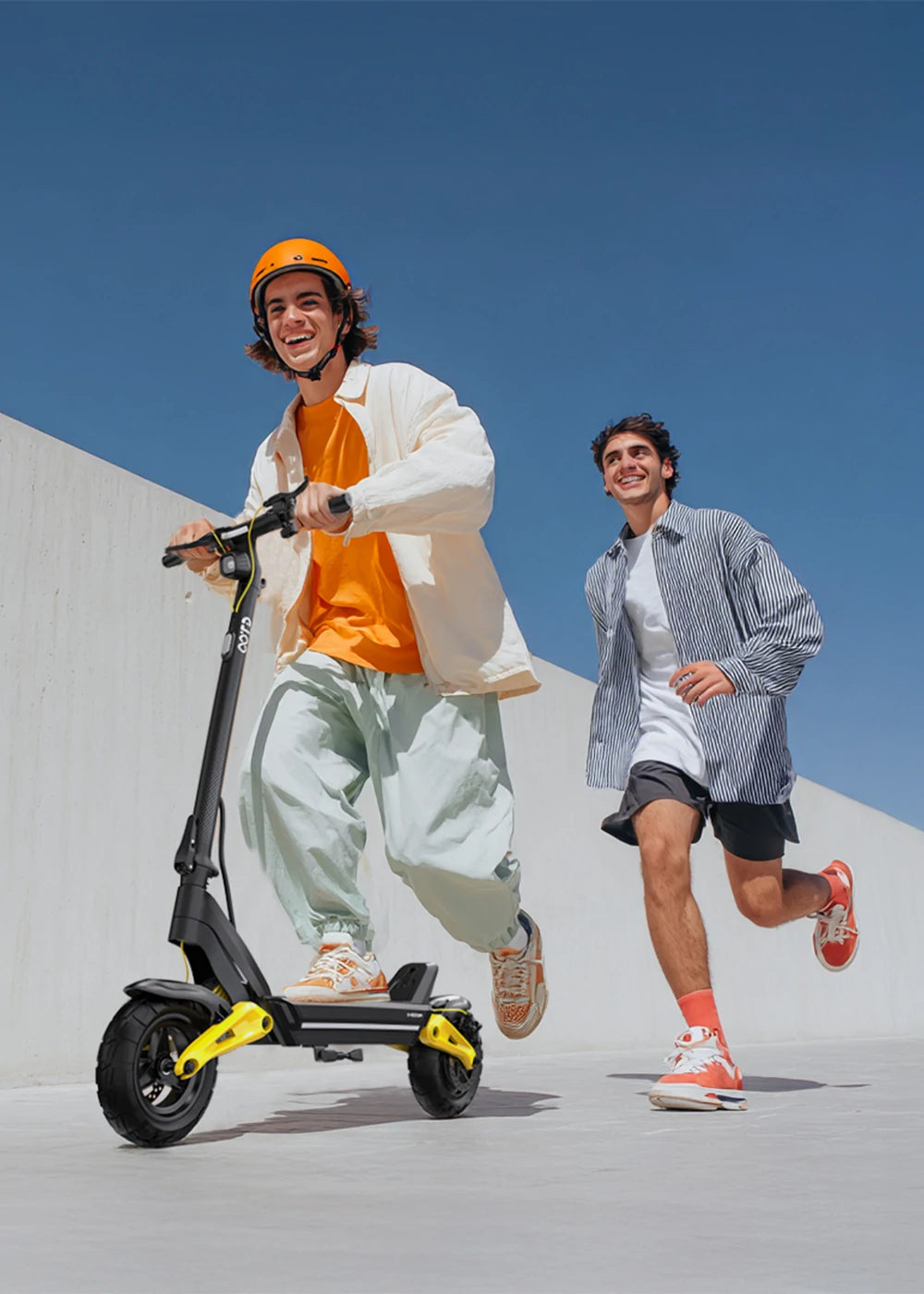 Three people with OOTD SR1 electric scooters by a park lake, showcasing the SR1's stylish black design with colorful LED deck lights and yellow accents, ideal for urban commuting and outdoor adventures